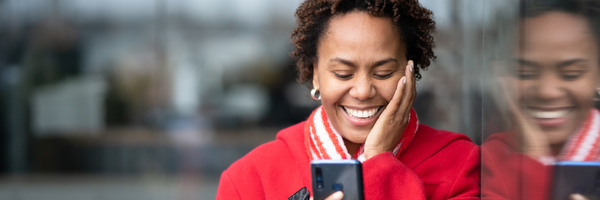 Woman looking happy at her phone.